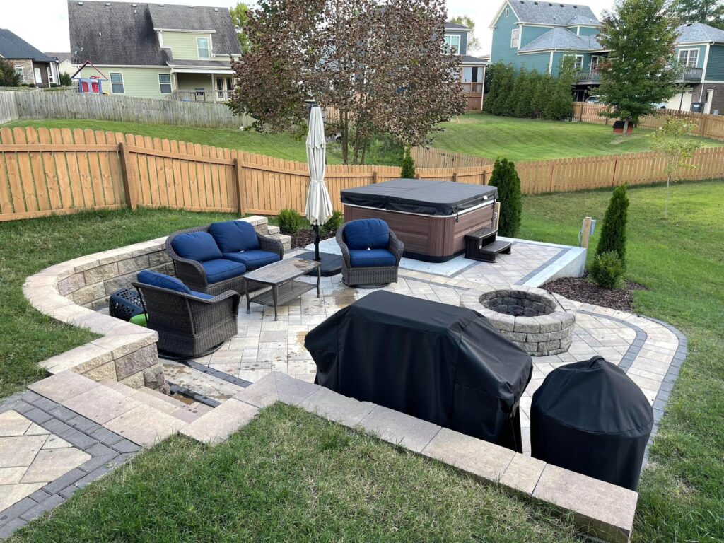 a concrete patio with couches and a beautiful fire pit and extended decorative concrete